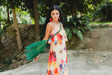 young sexy beautiful woman in colorful dress, summer hippie style, tropical vacation, tanned legs, sandals, green handbag with fringe, accessories, smiling, happy
