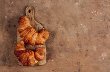 Fresh croissants on a wooden board