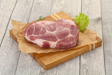 Raw pork steak over wooden board