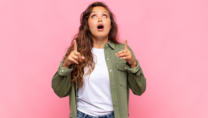 looking shocked, amazed and open mouthed, pointing upwards with both hands to copy space