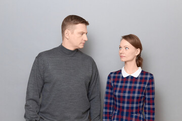 Portrait of serious man and woman looking attentively at each other