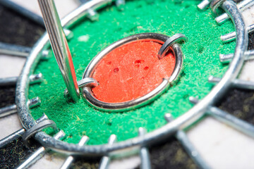 Blurred in soft focus at high magnification, an abstraction background with part of an old dart board with a close-up of the dart hit very close to the center. Concept - an attempt to achieve success