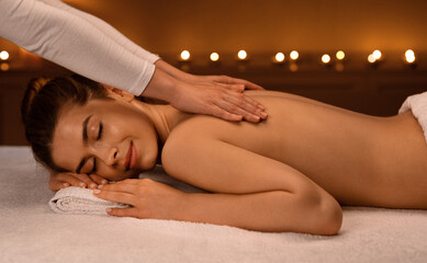 Woman getting healing body massage session at newest spa
