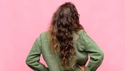  feeling confused or full or doubts and questions, wondering, with hands on hips, rear view