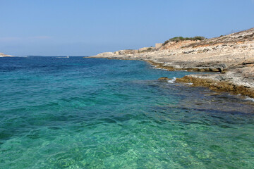 calm cyan sea with dry coast on Comino island, Malta