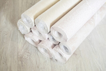 Several rolls of pastel paper wallpaper for wall renovation. Paperhangings on the floor.