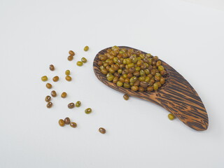Mung bean, Green moong dal in wooden spoon on white wooden background.