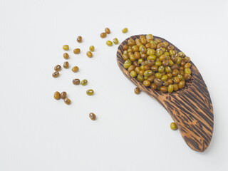 Mung bean, Green moong dal in wooden spoon on white wooden background.