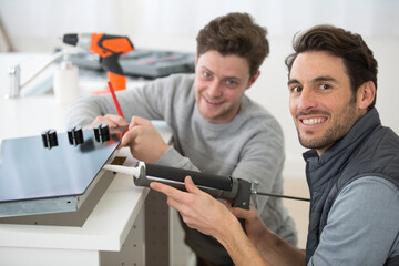 technician and apprentice using a silicon gun