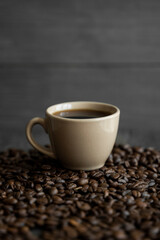 Cup of coffee with roasted coffee beans background. Mug of black coffee.