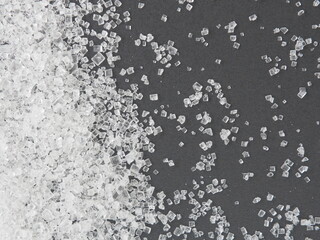 Close up white sugar on black background, warned that the sugar too much will make unhealthy nutrition, obesity, diabetes, dental care and much more.