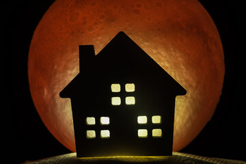 The silhouette of a Horror haunted house. There's a red full moon in the background. Halloween...