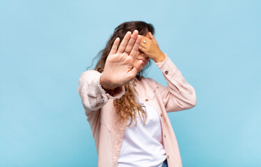  covering face with hand and putting other hand up front to stop camera, refusing photos or pictures