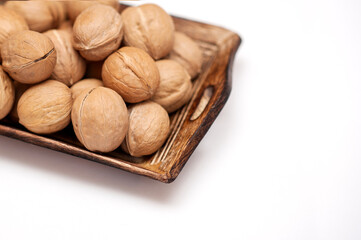 walnuts in a wooden bowl on a white background. isolate