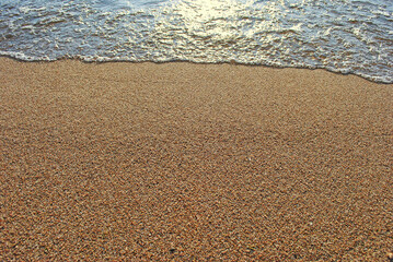 Sand on the beach and oncoming wave