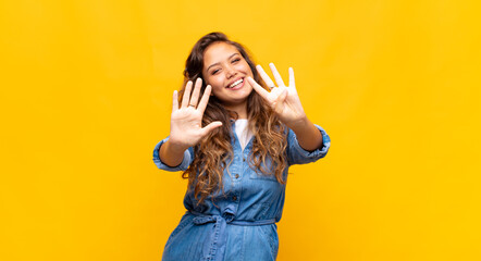  smiling and looking friendly, showing number nine or ninth with hand forward, counting down