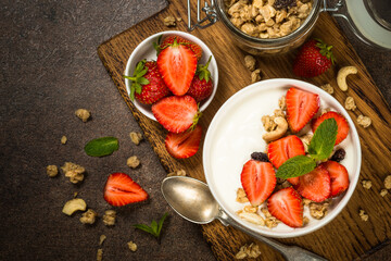 Yogurt with granola and strawberry in white bowl