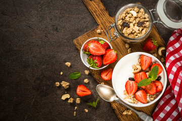 Yogurt with granola and strawberry in white bowl