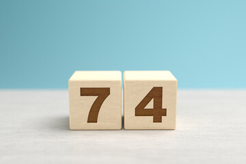 Wooden toy blocks forming the number 74.