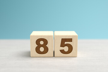 Wooden toy blocks forming the number 85.