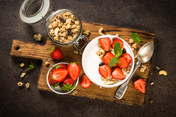 Yogurt with granola and strawberry in white bowl