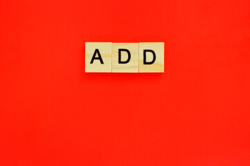 Word add. Wooden blocks with lettering on top of red background. Top view of wooden blocks with letters on red surface