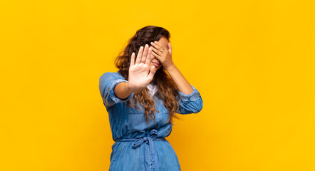  covering face with hand and putting other hand up front to stop camera, refusing photos or pictures