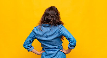  feeling confused or full or doubts and questions, wondering, with hands on hips, rear view