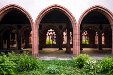 Cathedral in Baser. Beautiful cloister with inner garden, archway, shadow and light. Place for contemplation. Basel minster, Switzerland