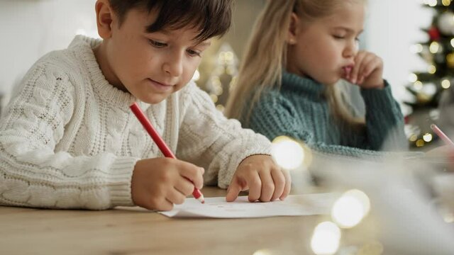 Close up video of little boy writing a letter to Santa Claus. Shot with RED helium camera in 8K.