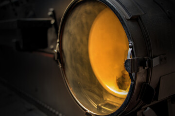 An old lamp of a steam locomotive shines to forward on track. Retro light in front part of train.