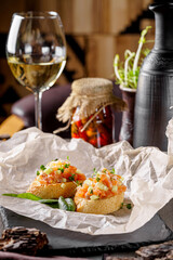 Italian Cuisine. Salmon baguette bruschetta, tomato and avocado. Serving food in a restaurant on parchment. Background image.