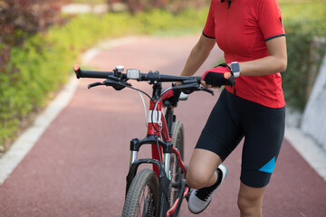 Woman cyclist riding mountain bike outdoors
