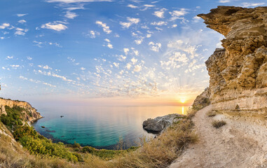 panorama on sunset time with beautiful clouds in the rocky bay with crystal clear azure sea on a...