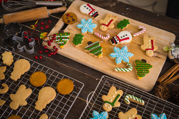 Freshly baked Christmas cookies on wooden table. Top view of xmas tree and snowman biscuits.