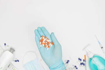 hand in glove with capsules on white background covid-19 coronavirus prevention concept flat lay