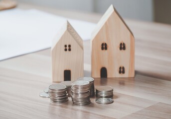 Stack of coins money with wood house model on table, Business Growth concept, Financial risk. for plan saving finance and banking business concept.