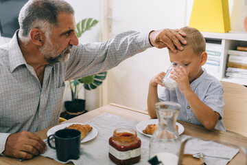 grandfather and grandson having breakfast at home