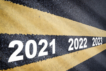 Year 2021 to 2023 on asphalt road with marking lines for giving directions. Future ahead concept...