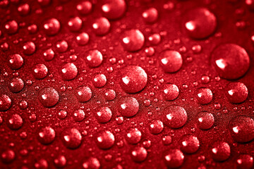 Red water drops on a glitter surface. Abstract stock photography. Macro droplets