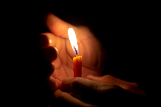 Men hand holding a candle in The dark light. Birthday concept