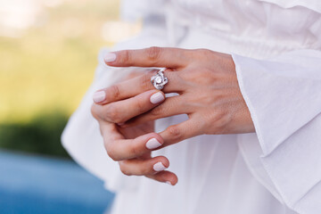Close outdoor shot of womans hands wearing ring.