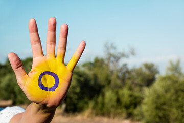 the intersex flag in the palm of the hand