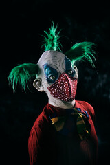 disturbing evil clown wearing a red face mask