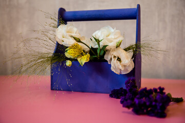 gift box with flowers on a colored background. Gift of flowers. White roses with orchids.