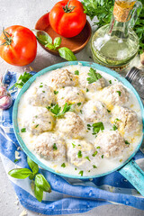 Homemade creamy white chicken meatballs. Classic Swedish meatballs with creamy cheesy sauce, with parmesan cheese and parsley, in skillet on grey stone table background