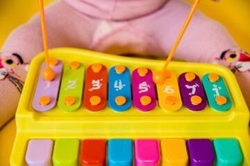 a small child plays with a toy xylophone. Musical toy. Educational games for preschoolers.