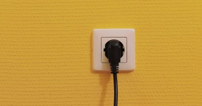Electric outlet plugging and unplugging a power cord, European Type F
