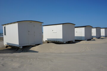 Obraz na płótnie Canvas typische Badehäuser, Strandhütten im Sand am Strand von Lökken in Dänemark