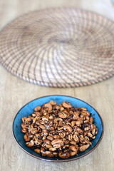 Bowl of roasted nuts, served on a table. Selective focus.